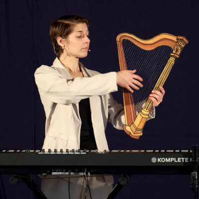 une comédienne jouant de la harpe pendant une représentation théâtrale du CCDM